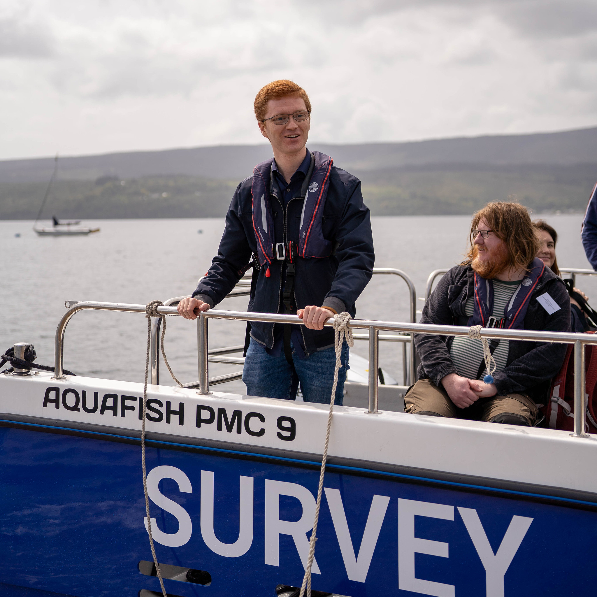 Ross Greer in lifejacket standing aboard survey vessel